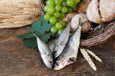 9279319-bread-and-fish-with-wine-grapes-symbolizing-the-miracles-of-jesus-christ